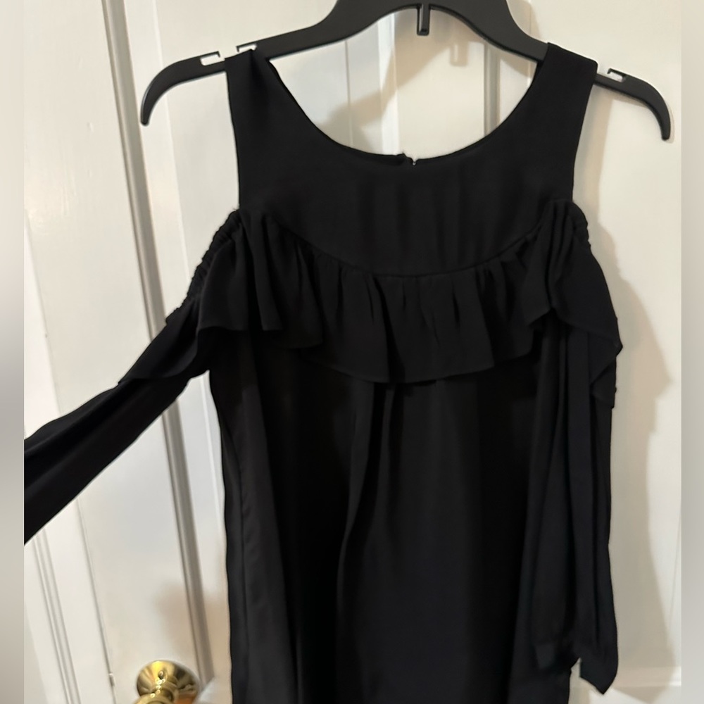 Cut out shoulder blouse with ruffle accent/long sleeves.
